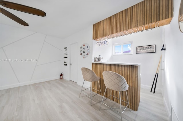 bar featuring light wood-type flooring and ceiling fan