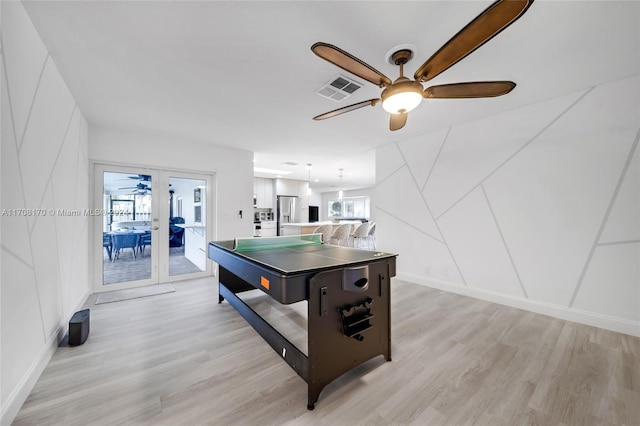 game room featuring french doors, light wood-type flooring, and ceiling fan