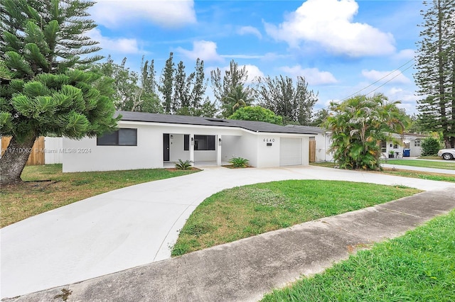 ranch-style house featuring a garage and a front yard