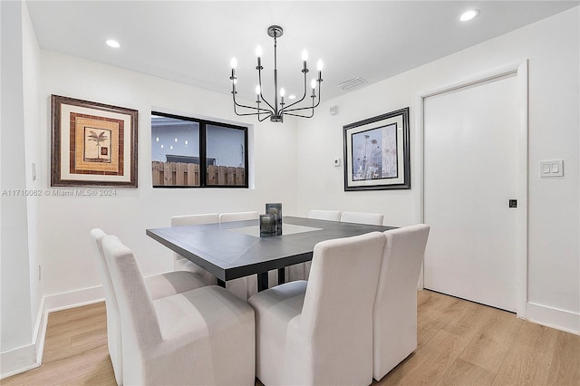 dining space featuring light hardwood / wood-style floors and an inviting chandelier