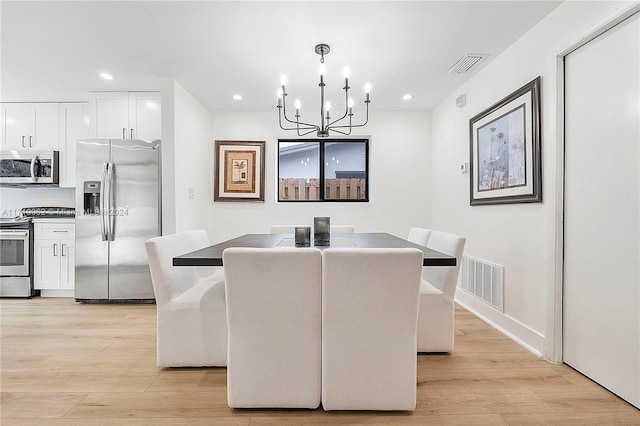 dining space featuring a notable chandelier and light hardwood / wood-style flooring