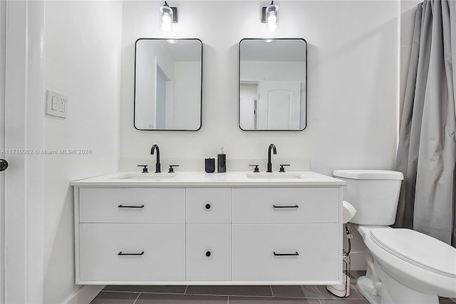 bathroom with tile patterned flooring, vanity, and toilet