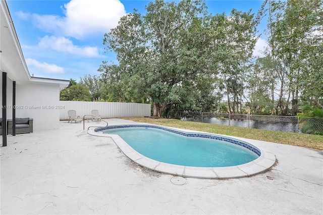 view of pool featuring a patio and a water view