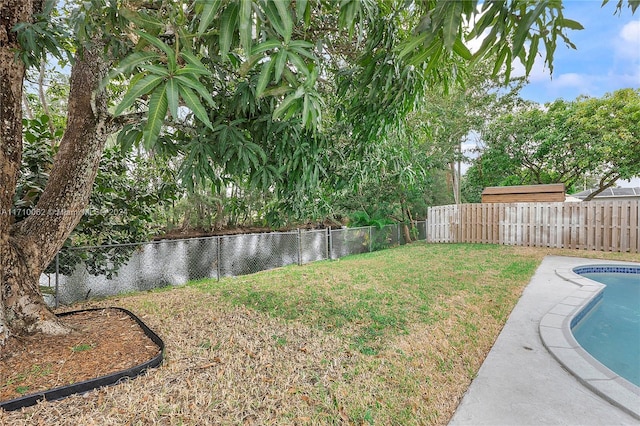 view of yard featuring a fenced in pool and a water view