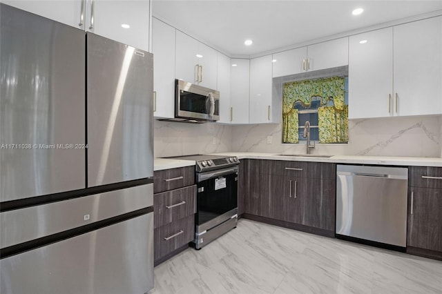 kitchen featuring white cabinets, dark brown cabinetry, stainless steel appliances, and sink