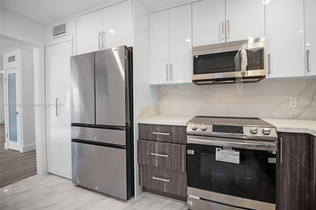 kitchen featuring white cabinets, dark brown cabinetry, and stainless steel appliances