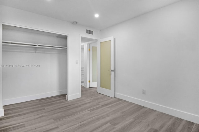 unfurnished bedroom featuring light wood-type flooring and a closet