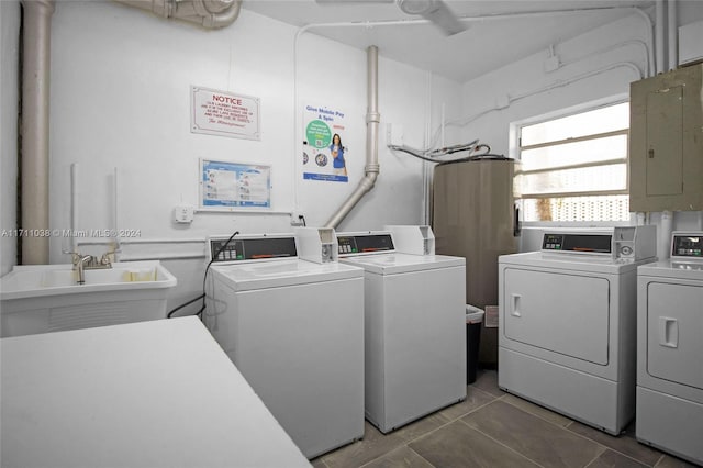 laundry room featuring electric panel, washer and clothes dryer, tile patterned flooring, and sink