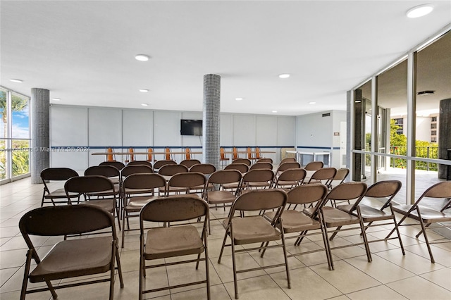 dining room with light tile patterned floors and a wall of windows