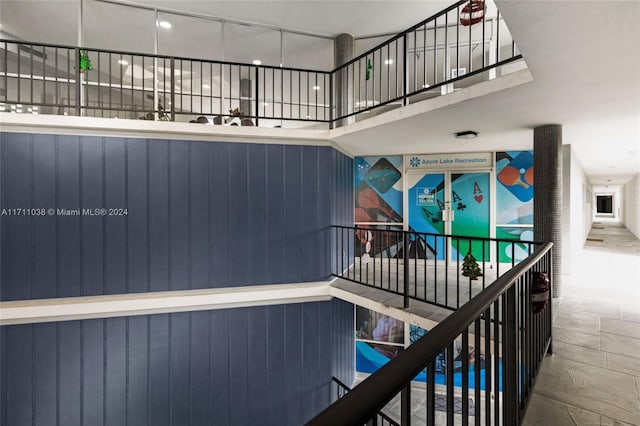 stairway featuring wooden walls