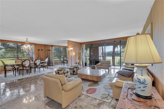 living room featuring a wealth of natural light, a textured ceiling, and an inviting chandelier