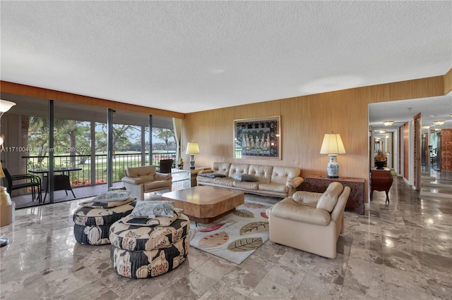 living room with a textured ceiling and wooden walls