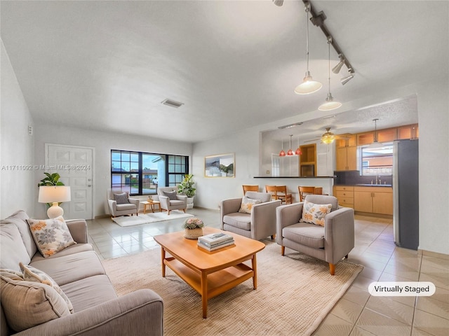 tiled living room with ceiling fan, sink, and track lighting