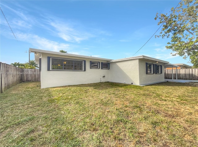 rear view of house featuring a yard