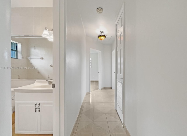 hallway with sink and light tile patterned flooring