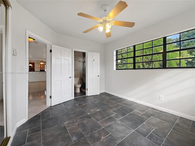 unfurnished bedroom featuring ceiling fan and ensuite bath