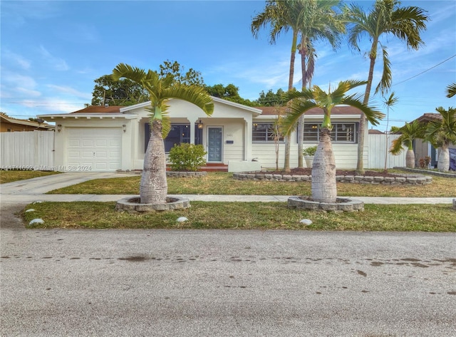 single story home featuring a garage and a front lawn