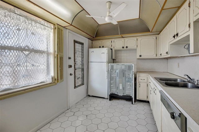 kitchen featuring dishwasher, white refrigerator, sink, ceiling fan, and white cabinetry