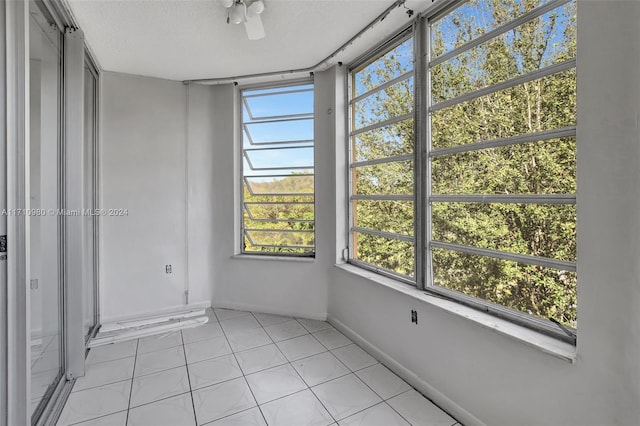 unfurnished sunroom with ceiling fan