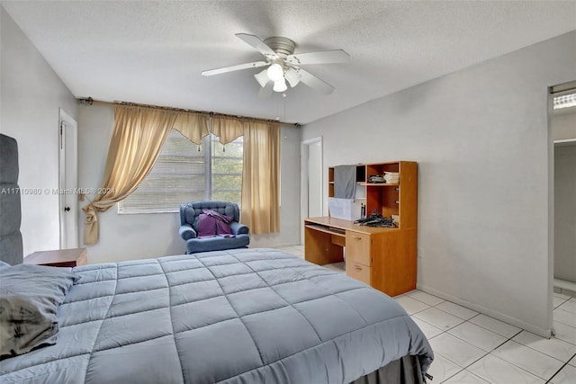 tiled bedroom with a textured ceiling and ceiling fan