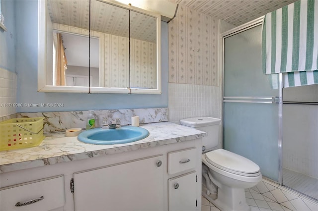 bathroom with tile patterned flooring, vanity, toilet, and walk in shower