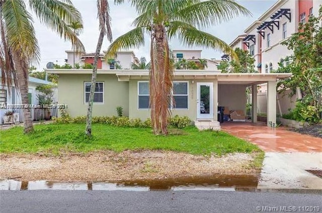 back of property featuring a lawn and a carport