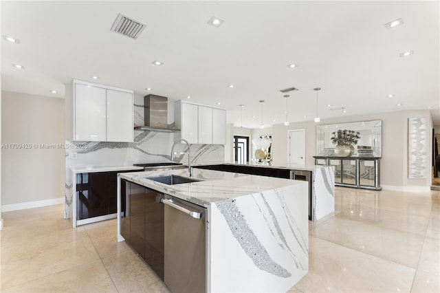 kitchen with dishwasher, sink, white cabinets, hanging light fixtures, and wall chimney exhaust hood