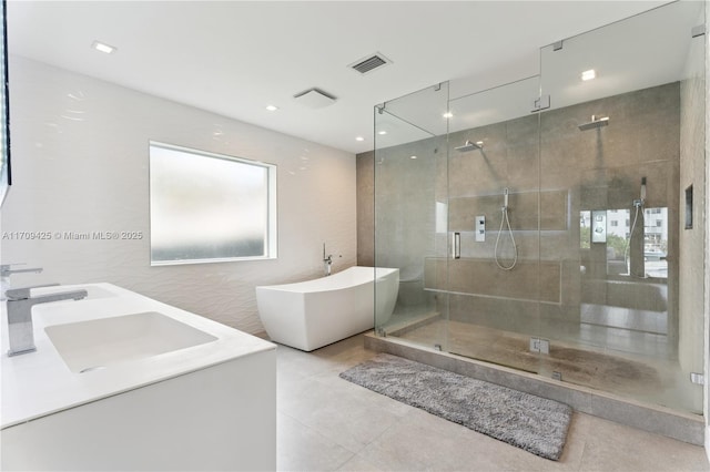 bathroom with tile walls, vanity, and independent shower and bath