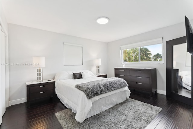 bedroom with dark hardwood / wood-style floors