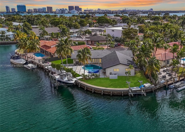 aerial view at dusk featuring a water view