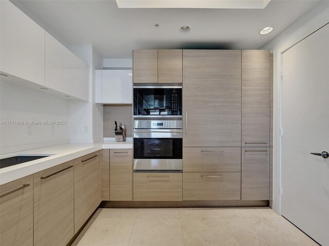 kitchen featuring stainless steel oven, extractor fan, built in microwave, sink, and white cabinets