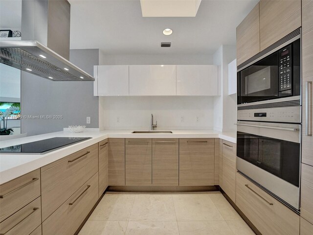 kitchen with black appliances, sink, light tile patterned floors, kitchen peninsula, and island exhaust hood