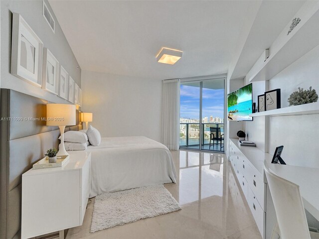 bedroom with access to exterior, light tile patterned floors, and expansive windows