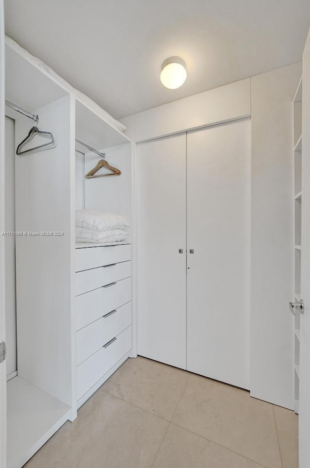 walk in closet with light tile patterned floors