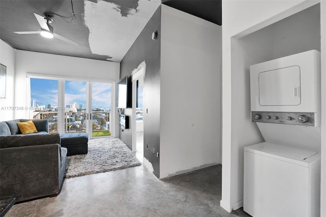 living room with ceiling fan, stacked washer and dryer, and concrete floors