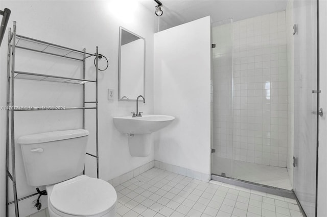 bathroom with tile patterned flooring, a shower with door, and toilet