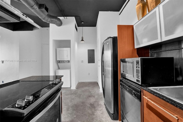 kitchen featuring appliances with stainless steel finishes, concrete flooring, stacked washer and dryer, electric panel, and hanging light fixtures