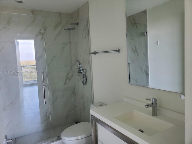 bathroom with vanity, a shower with shower door, and toilet