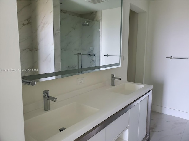 bathroom featuring a tile shower and vanity