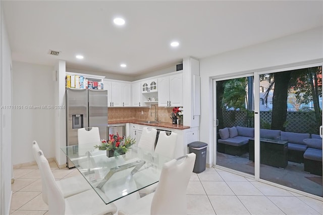 dining space featuring light tile patterned floors and sink