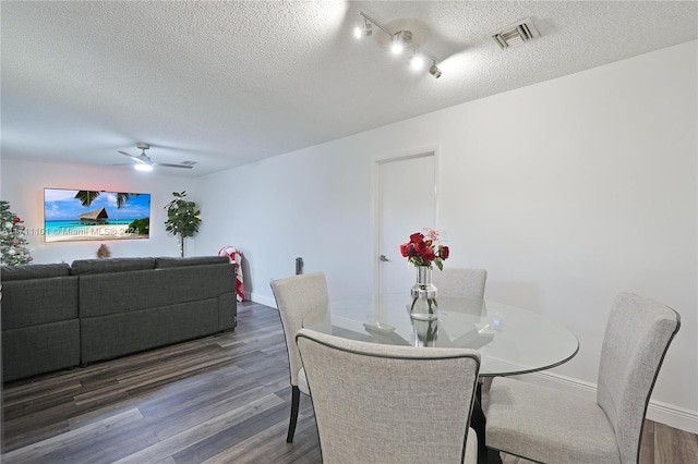 dining space featuring a textured ceiling, ceiling fan, and dark hardwood / wood-style floors