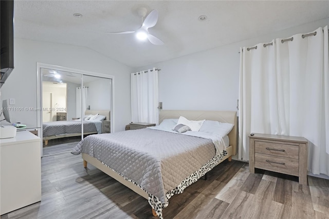 bedroom with hardwood / wood-style floors, ceiling fan, vaulted ceiling, and a closet