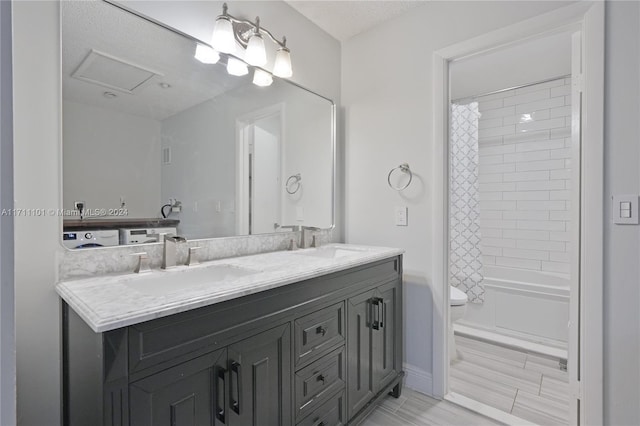 full bathroom featuring vanity, toilet, shower / bath combo, and washer / clothes dryer