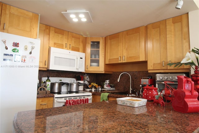 kitchen with white appliances, glass insert cabinets, and tasteful backsplash