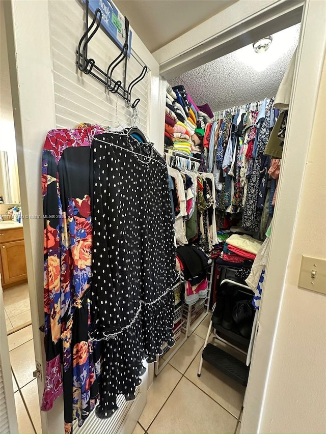 walk in closet with a sink and tile patterned floors