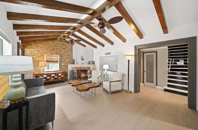 living room with vaulted ceiling with beams, ceiling fan, and light hardwood / wood-style flooring