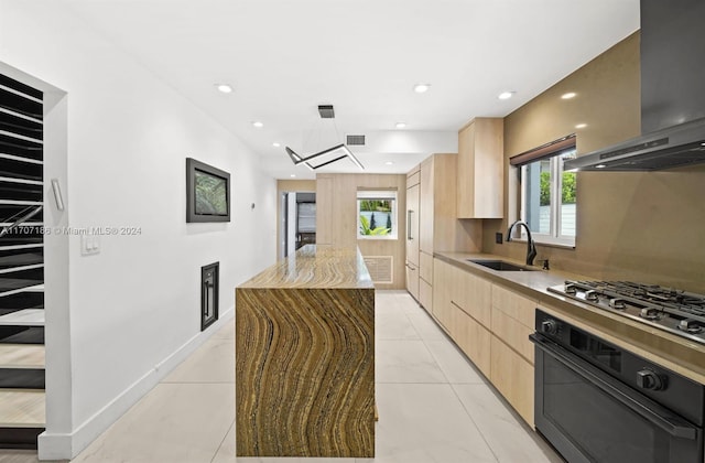 kitchen featuring sink, a center island, plenty of natural light, extractor fan, and black oven