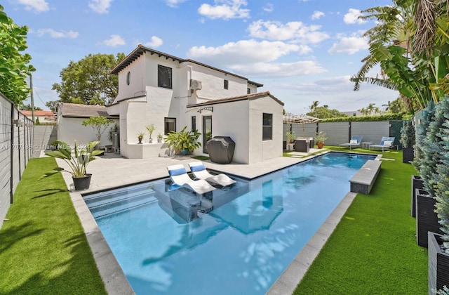 rear view of house with a fenced in pool, a lawn, and a patio