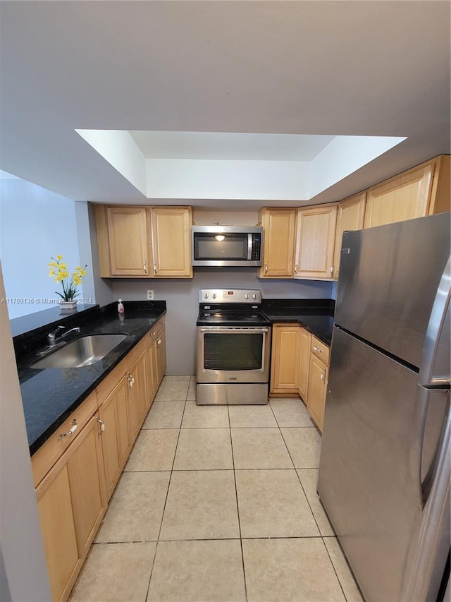 kitchen featuring light brown cabinetry, sink, light tile patterned flooring, and stainless steel appliances