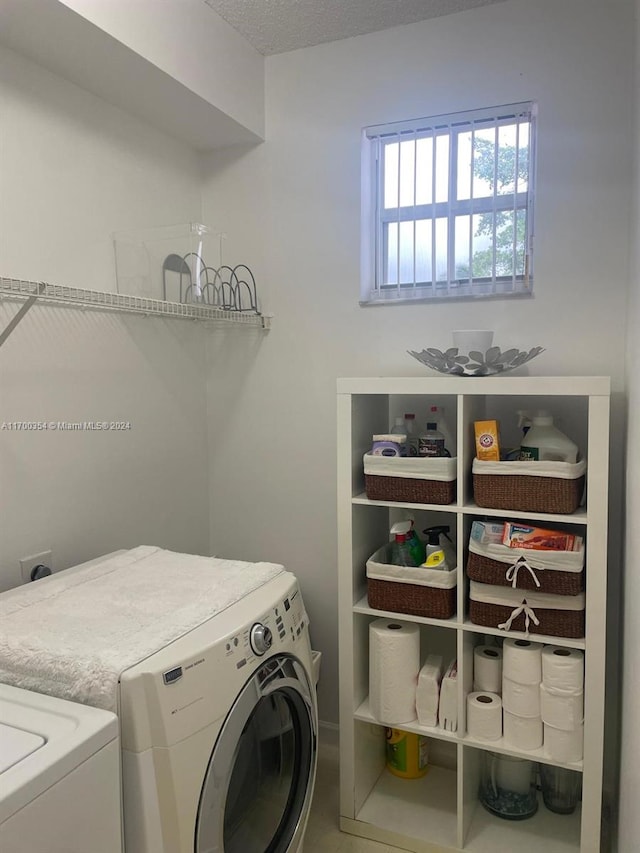 clothes washing area featuring washer and dryer and a textured ceiling